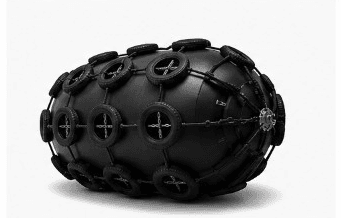 Pneumatic fender with chain and tyre net between ship and quay